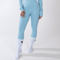 Light blue leggings worn with a matching long-sleeved top and white crew socks against a plain white background.