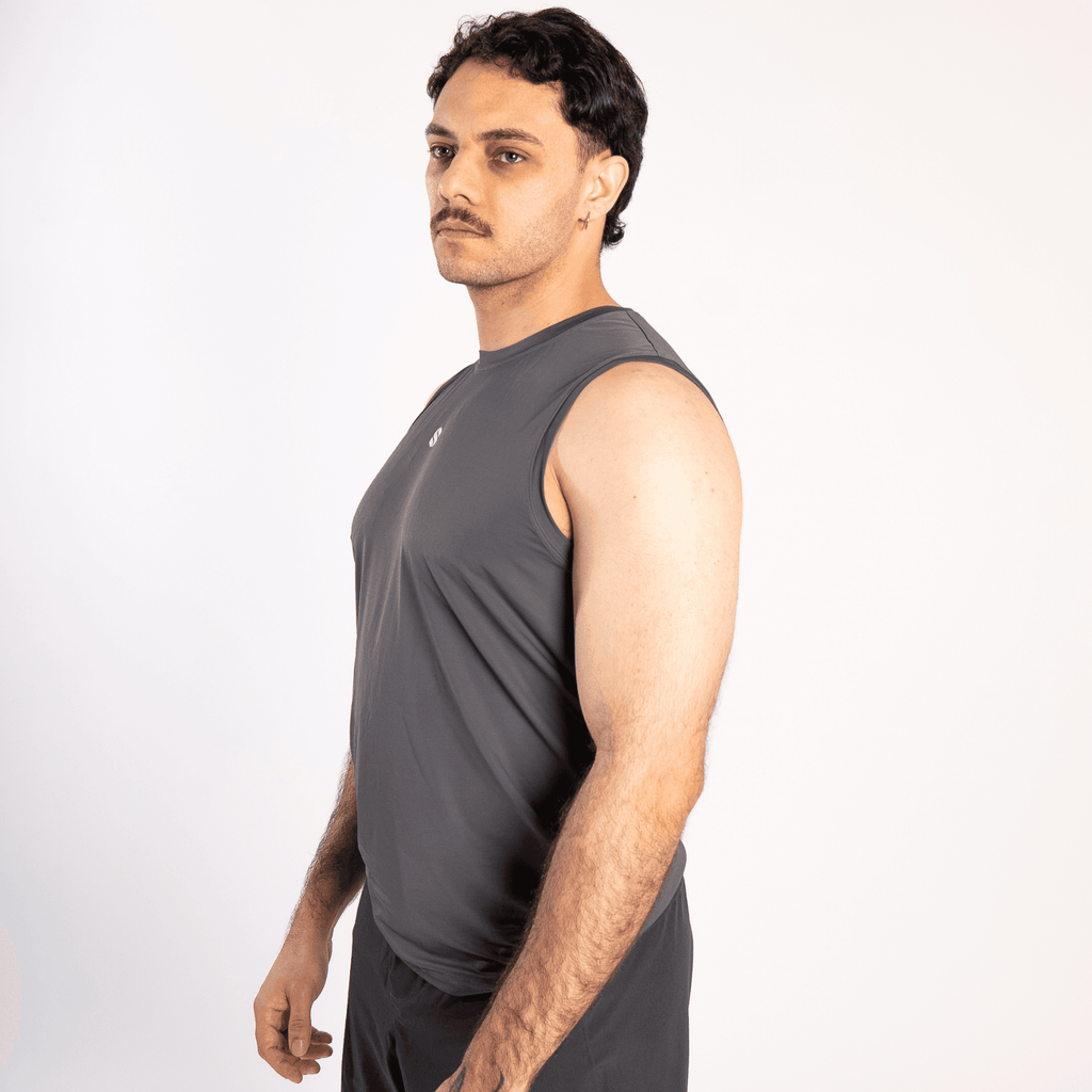 A man wearing a dark grey sleeveless crew-neck athletic shirt viewed from the side against a plain white background.
