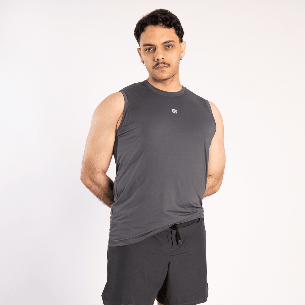 A man wearing a charcoal grey sleeveless crew neck tank top with a small white logo on the chest and matching black athletic shorts against a plain white background.