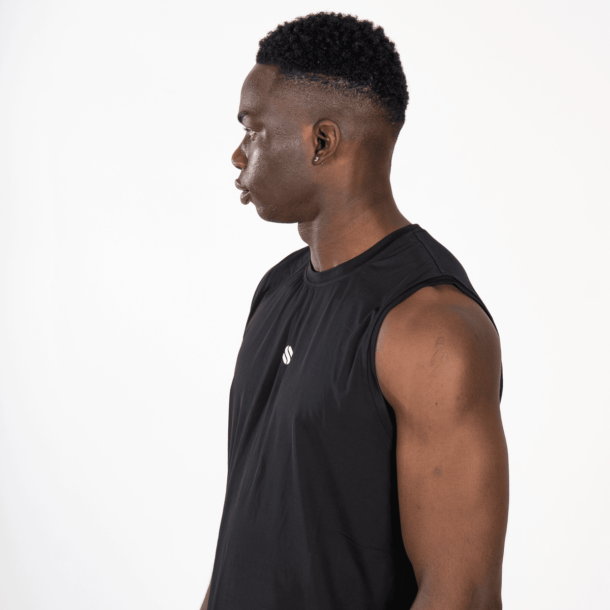 A black sleeveless athletic shirt worn by a man in profile against a plain white background.