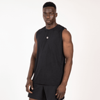 A man wearing a plain black sleeveless workout tank top and matching black athletic shorts stands against a white background.